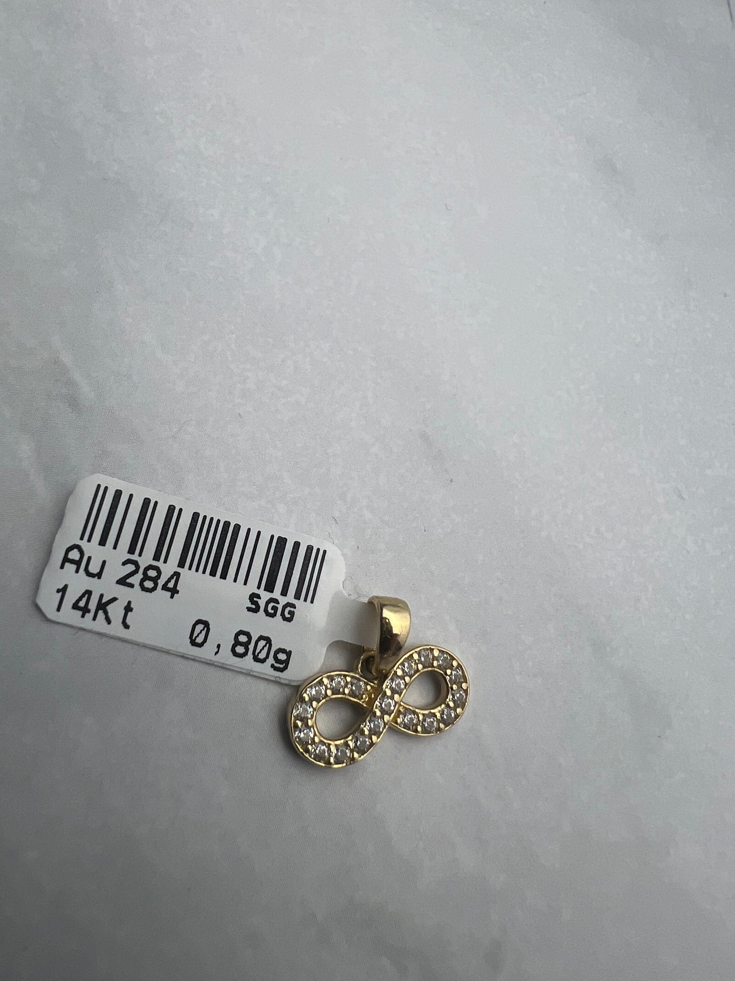 Végtelen formájú arany medál fehér cirkónia kövekkel díszítve