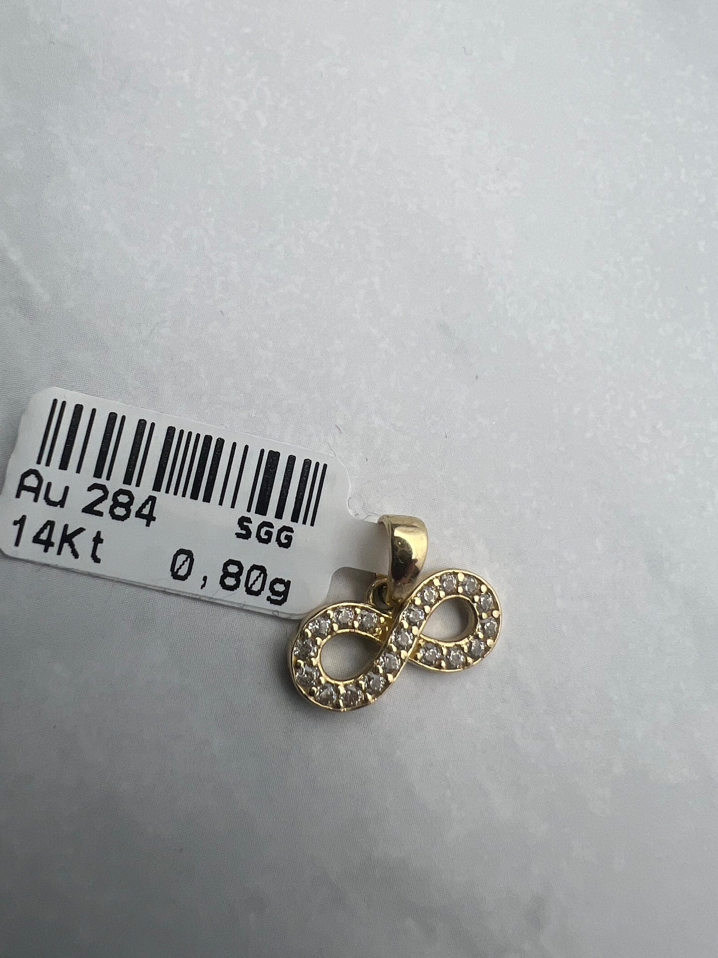 Végtelen formájú arany medál fehér cirkónia kövekkel díszítve