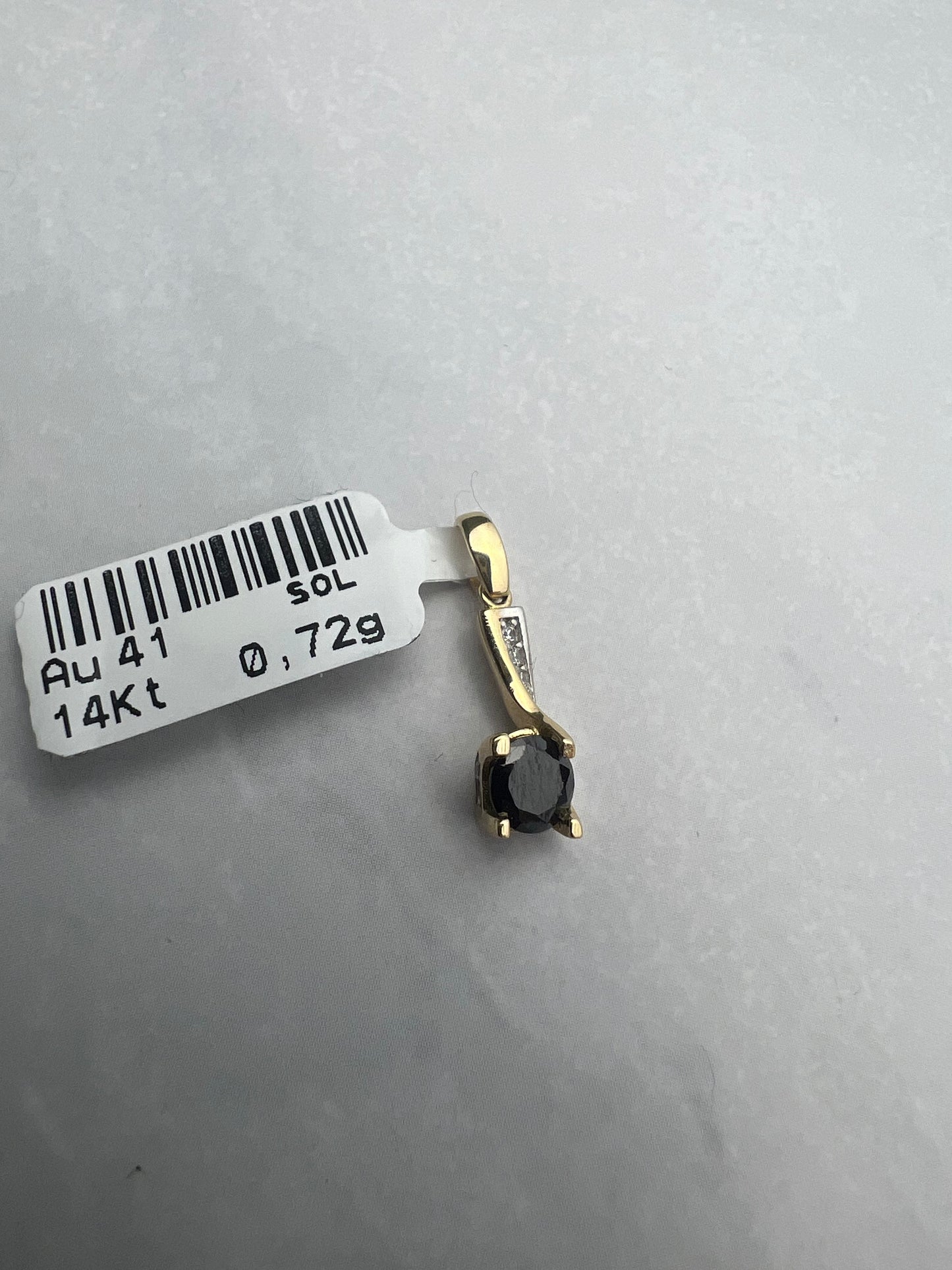 Extravagáns arany medál fekete főkővel és fehér pici kövekkel