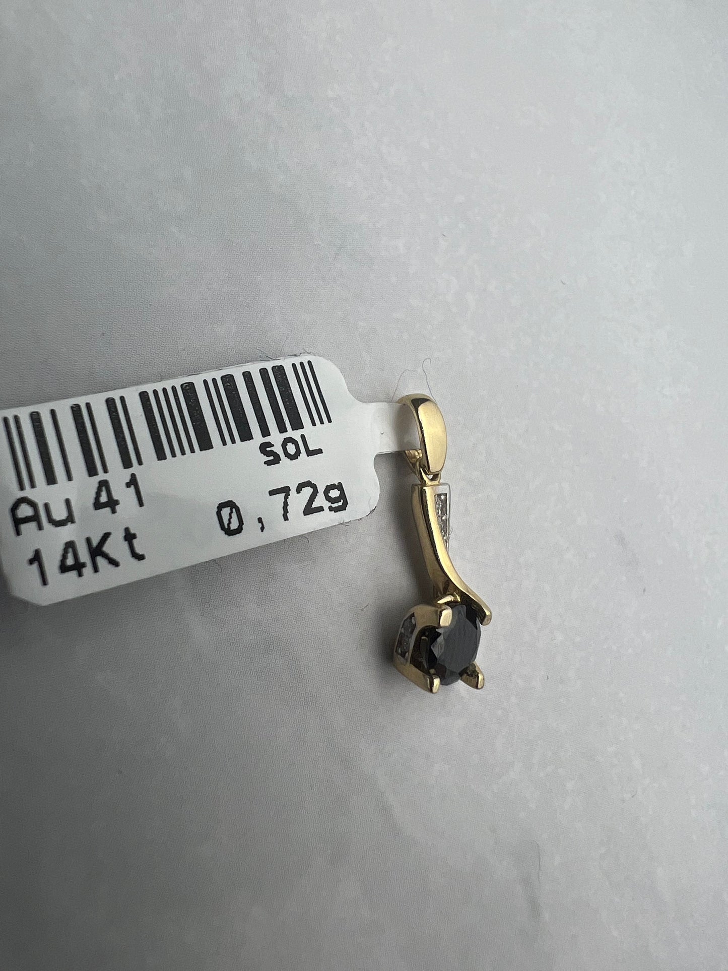 Extravagáns arany medál fekete főkővel és fehér pici kövekkel