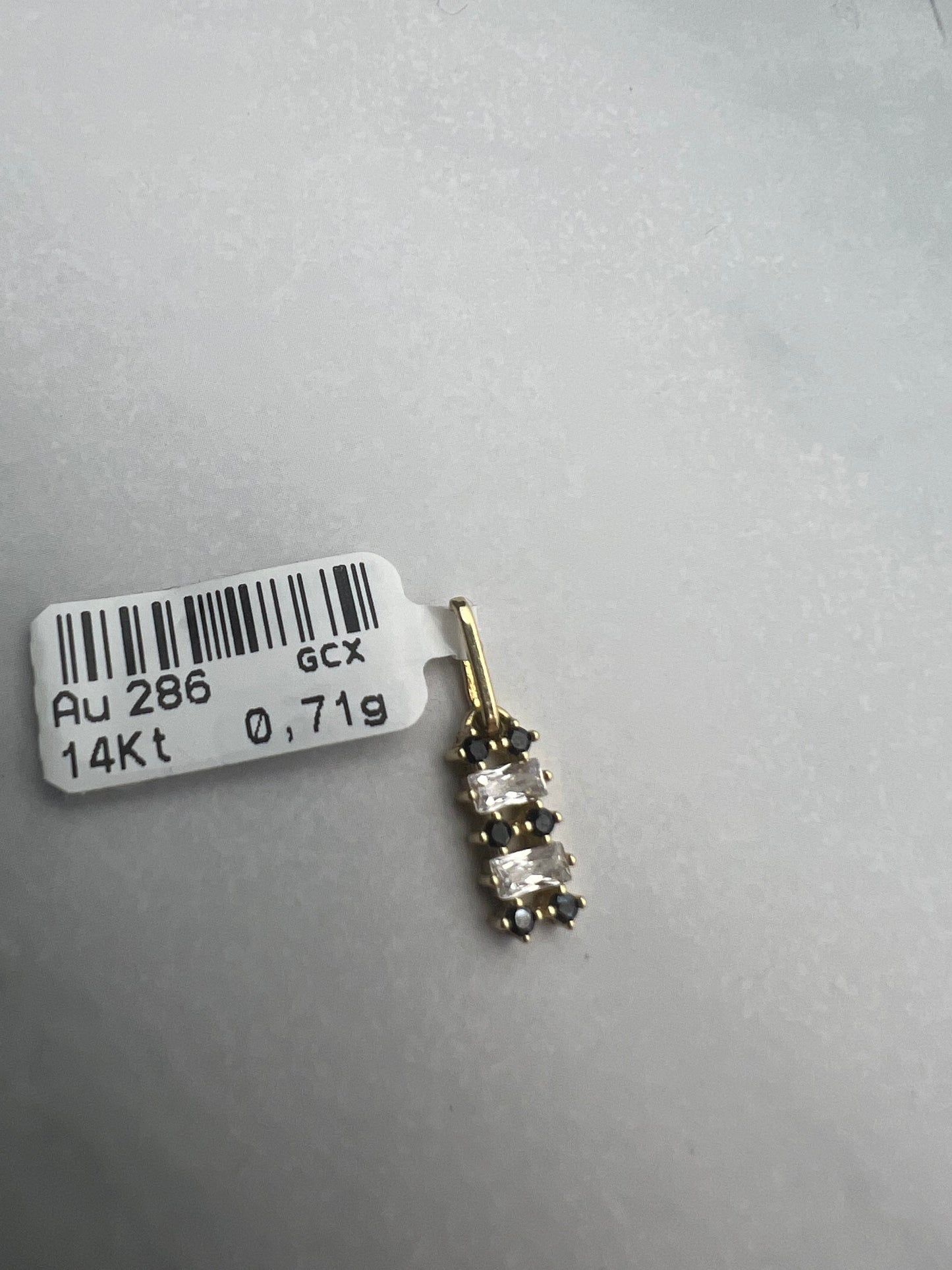 Téglalap alakú, vízssintesen fekete és fehér cirkónia kövekkel díszített arany medál