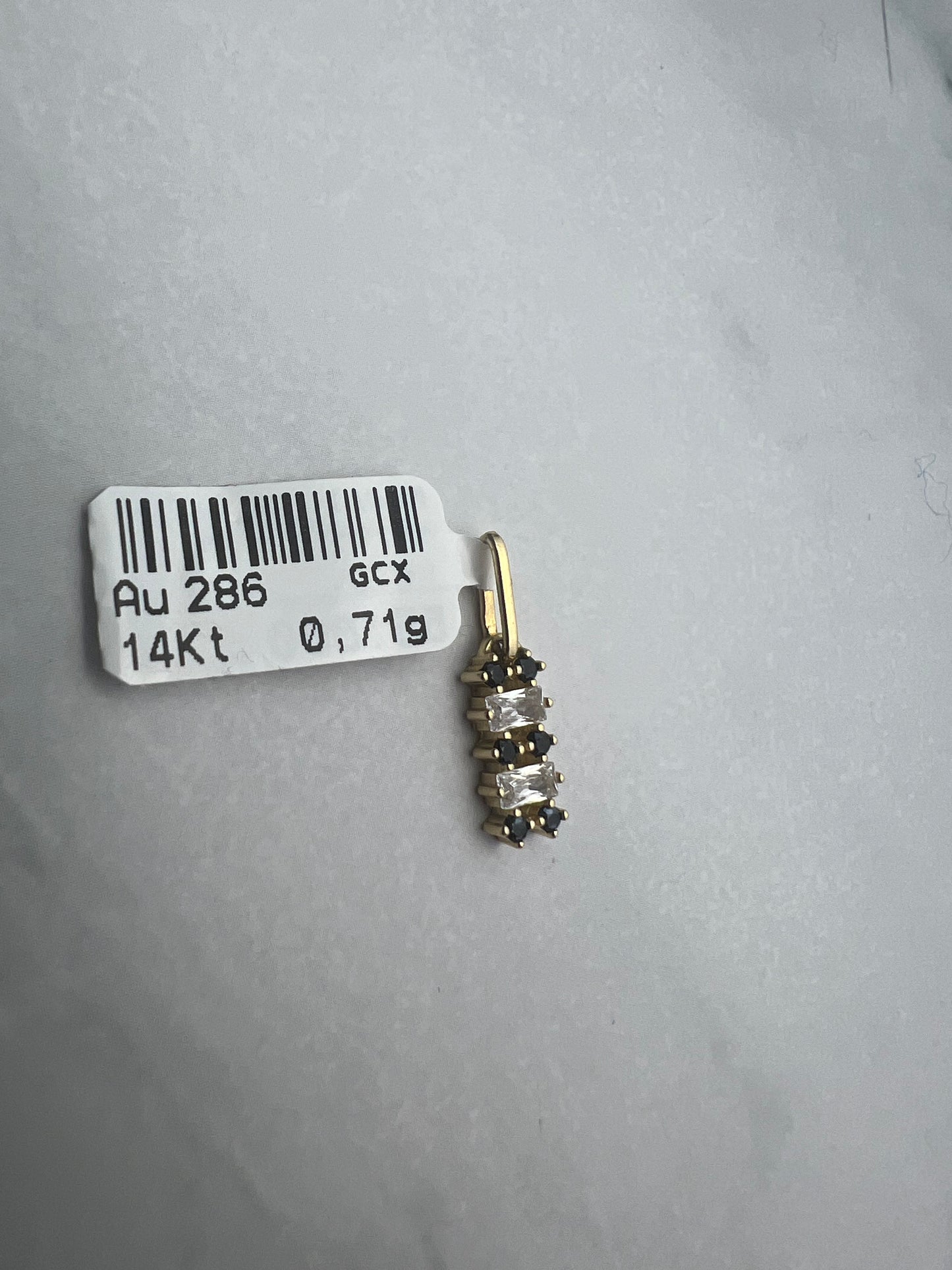 Téglalap alakú, vízssintesen fekete és fehér cirkónia kövekkel díszített arany medál