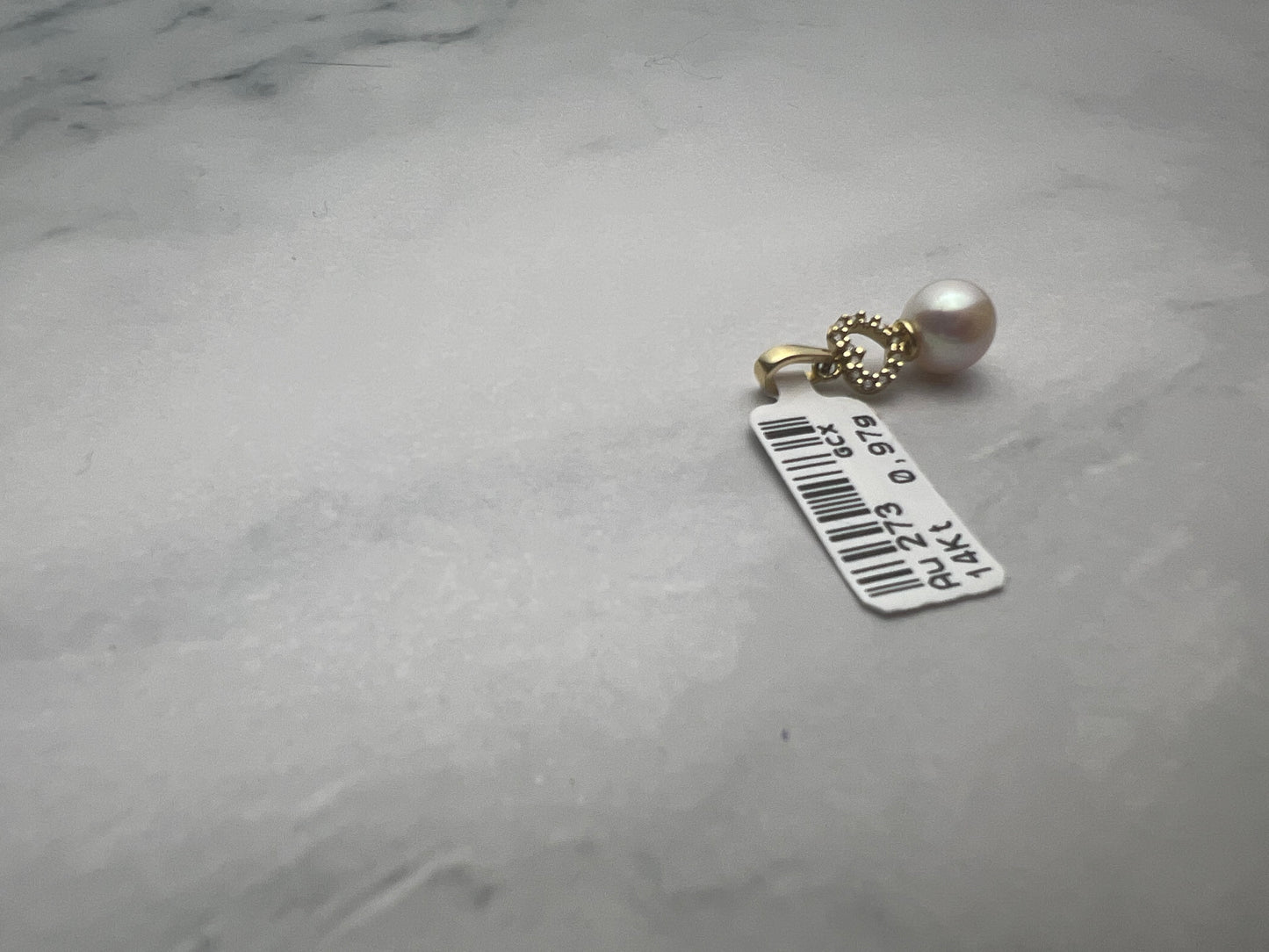 Gyönggyel, felette fehér cirkónia kövekkel díszített szív motívummal kombinált arany medál